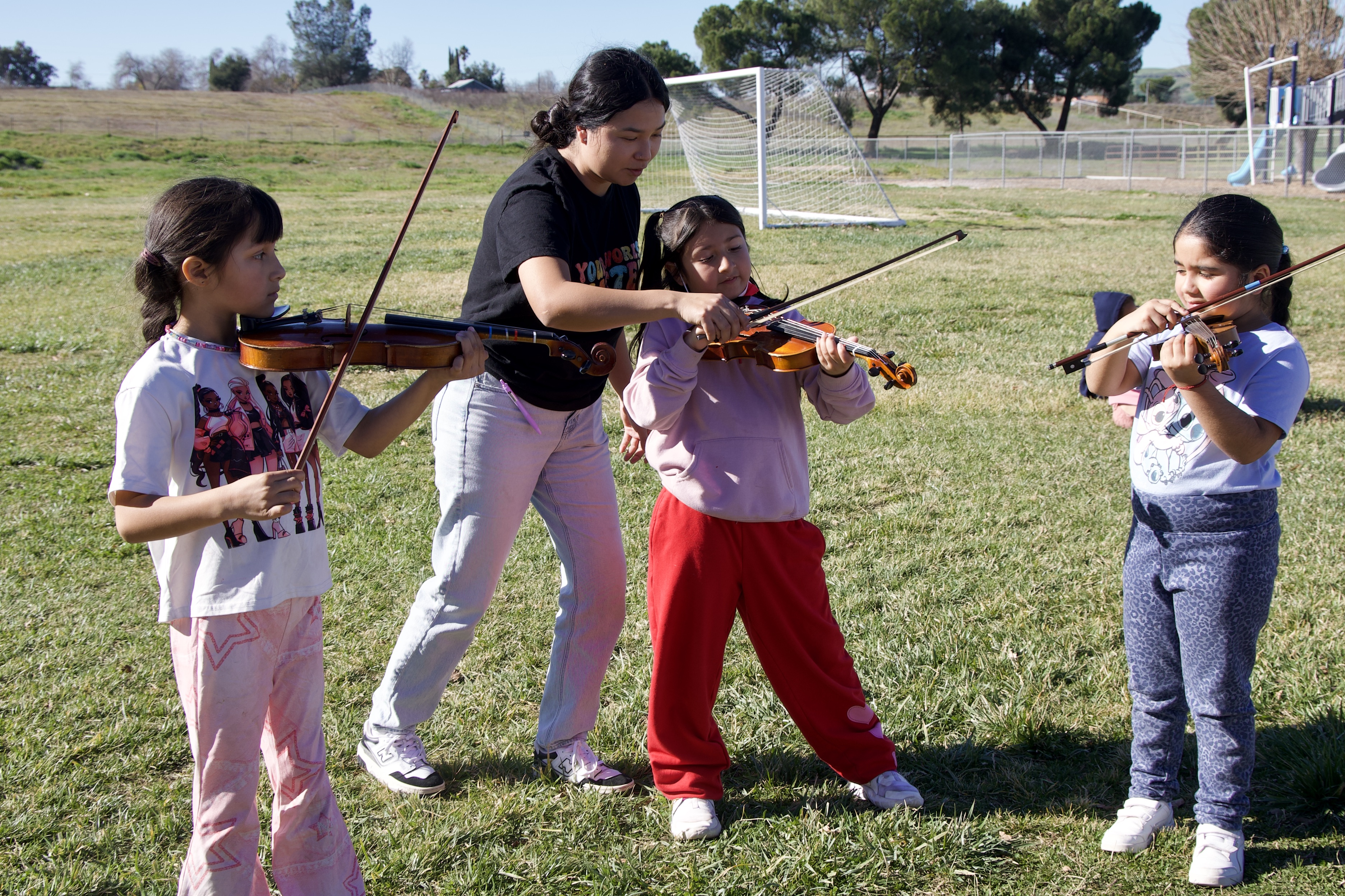 Students trying out the violin as part of the Music Van arts outreach at Shandon Elementary School